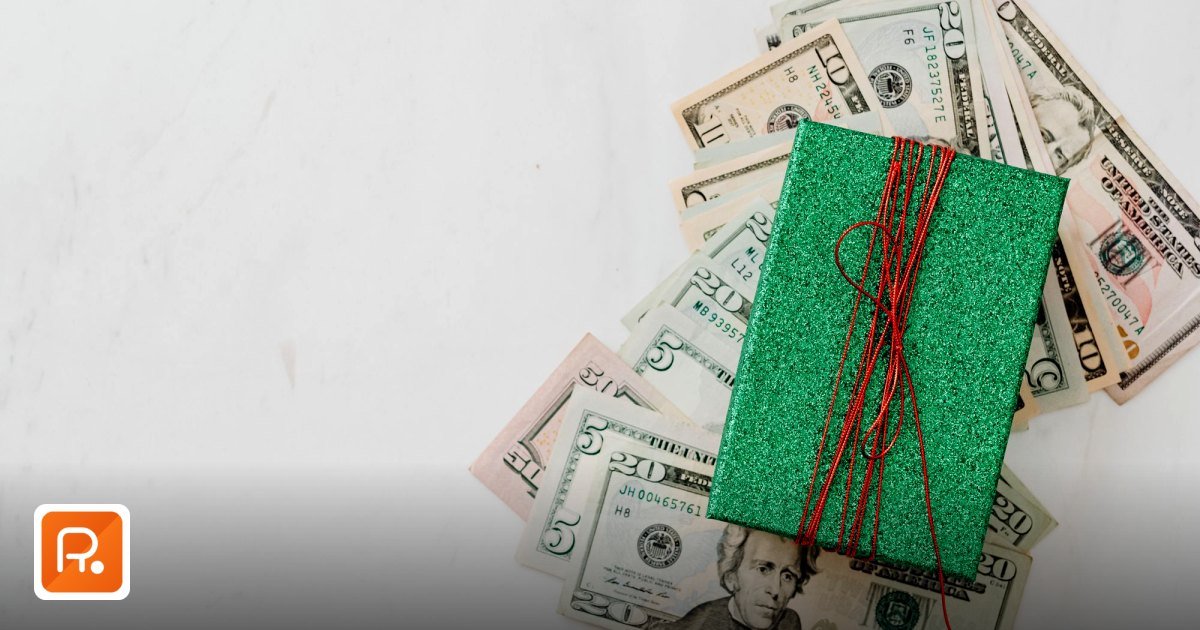 Corporate Gift Spend KPI Dashboard UAE: Benchmarking Guide - green gift box on a pile of dollar banknotes