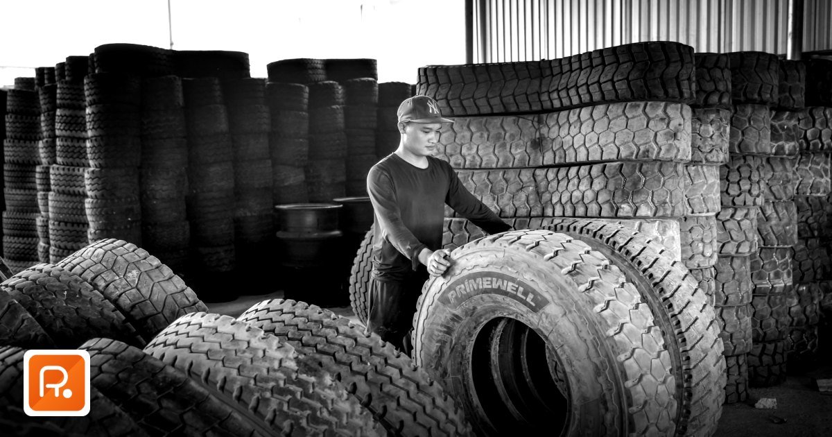 Commercial Tyre Wholesale Suppliers UAE 2026: Industrial & OTR B2B Sourcing Guide - black and white photo of a man stacking